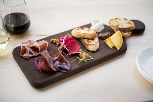 Charcuterie board with two wine glasses on the side